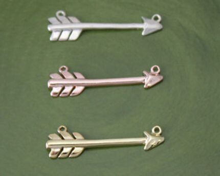 Three metal arrow pendant charms on green background