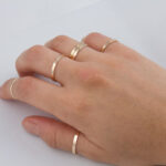 Hand with multiple thin gold rings