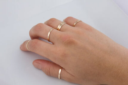 Hand with multiple thin gold rings