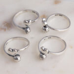 Silver rings with heart and sports ball charms
