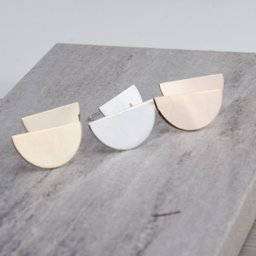 Three half-moon metallic stud earrings on slab Three half-moon metallic stud earrings on slab