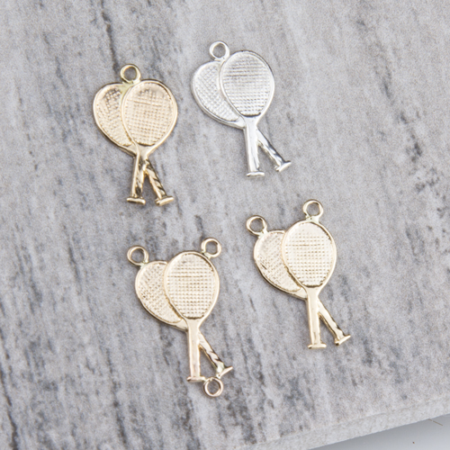 Four metallic tennis racket charms on gray background Four metallic tennis racket charms on gray background