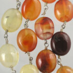 Close-up of amber colored oval bead necklace