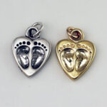 Silver and gold heart charms with baby footprints