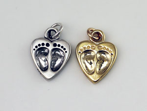 Silver and gold heart charms with baby footprints