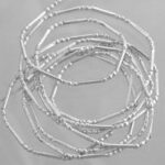 Stack of delicate silver beaded bracelets