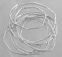 Stack of delicate silver beaded bracelets