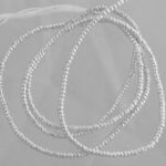 Tangled silver beaded chains on gray background
