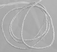 Tangled silver beaded chains on gray background