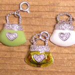 Three glittery heart purse charms on wood