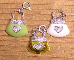Three glittery heart purse charms on wood