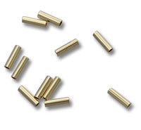 Brass tubular beads scattered on white background