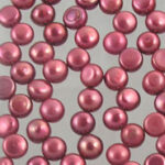 Scattered metallic pink beads on gray background