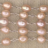 Linked pink freshwater pearls necklace on fabric