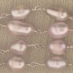 Lavender-pink baroque pearls on beige fabric