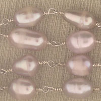 Lavender-pink baroque pearls on beige fabric