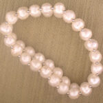 White pearl bracelet on beige fabric