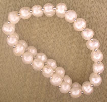 White pearl bracelet on beige fabric