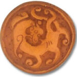 Round bronze medallion with stylized dragon