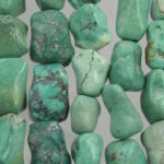 Green turquoise tumbled stones arranged in rows