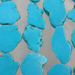Turquoise stone slices on gray background