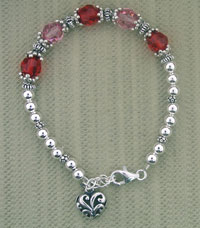 Silver bracelet with red beads and heart charm