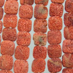 Rows of red-orange porous square beads