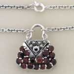 Silver handbag pendant necklace with red gemstones