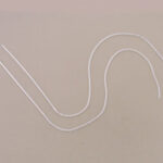 Two white cords curved on beige background