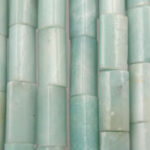 Pale green cylindrical beads in vertical rows