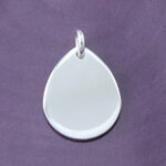 Blank teardrop silver pendant on purple background