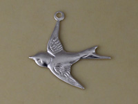 Silver swallow bird pendant on beige background