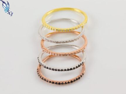 Stacked gold, silver, and rose-gold rings with stones