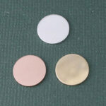 Three circular cosmetic pads on green background