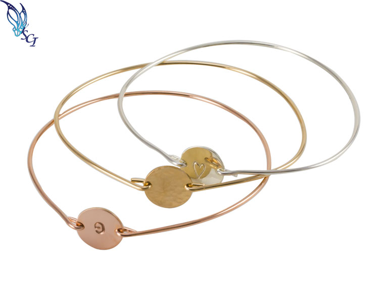 Three mixed-metal bangles with disc charms Three mixed-metal bangles with disc charms