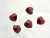 Five red heart-shaped sequins on white background